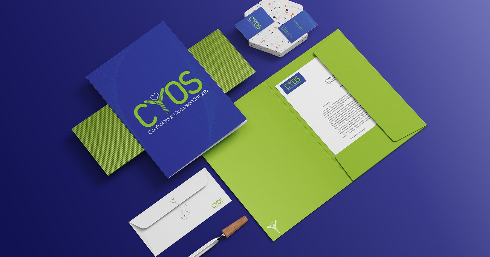 Ensemble de papeterie CYOS, lettre, enveloppe, pochette, document, cartes de visite, sur fond bleu, vue de dessus