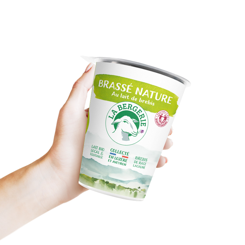 Packaging yaourt brassé nature La Bergerie, dans une main de femme, sur fond blanc